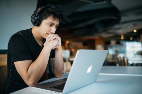 Guy staring at his laptop screen. Seems frazzled.